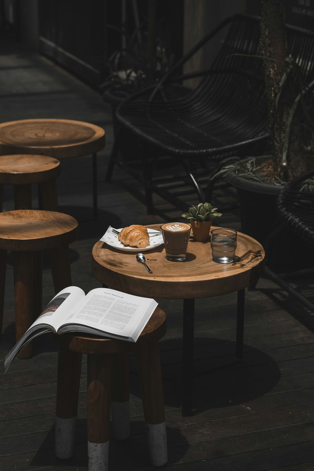 Meja kafe dengan buku terbuka dan cangkir minuman, melambangkan keseimbangan dan jeda